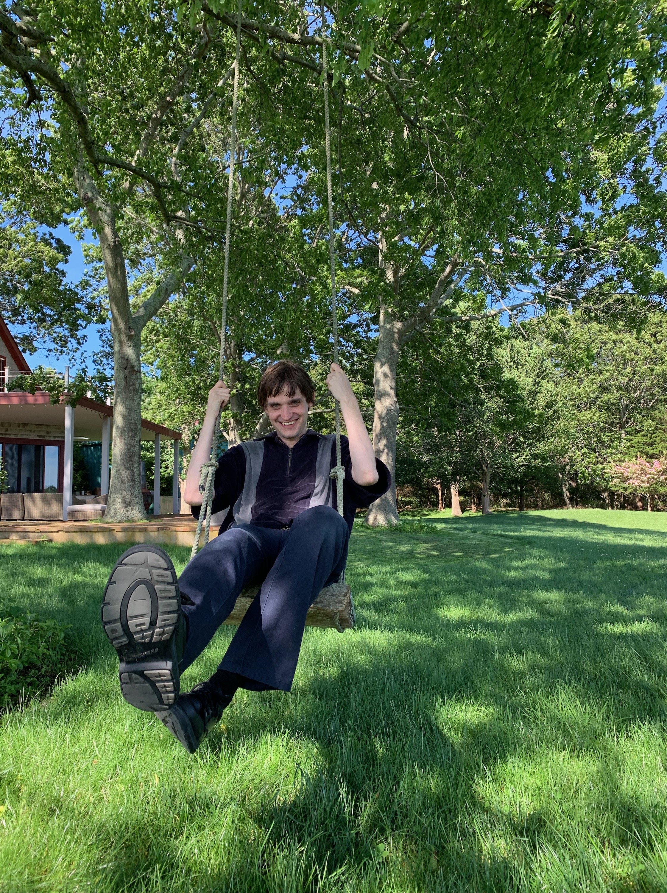 Juiceboxxx smiling on a swing