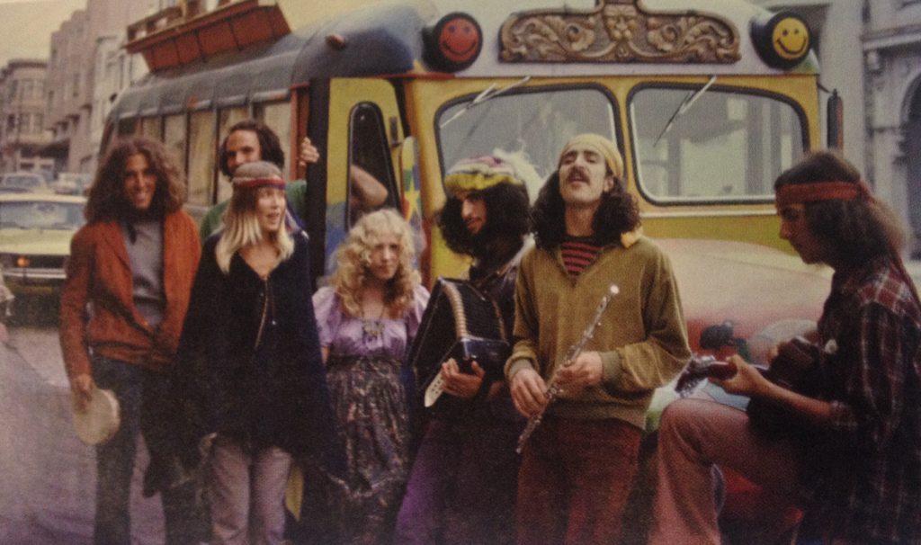 a group of hippies hippies in front of a tour van