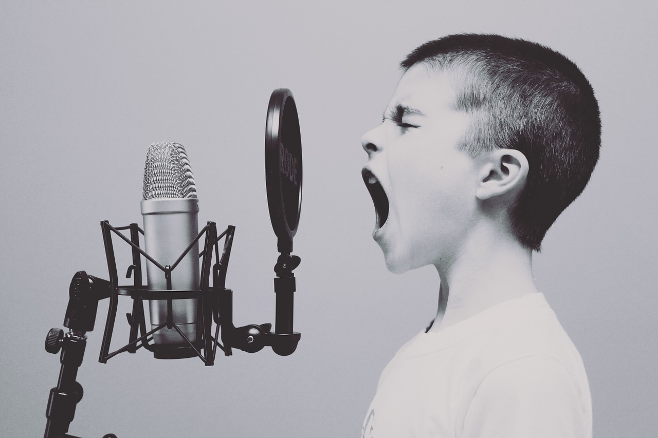 kid singing in front of a microphone